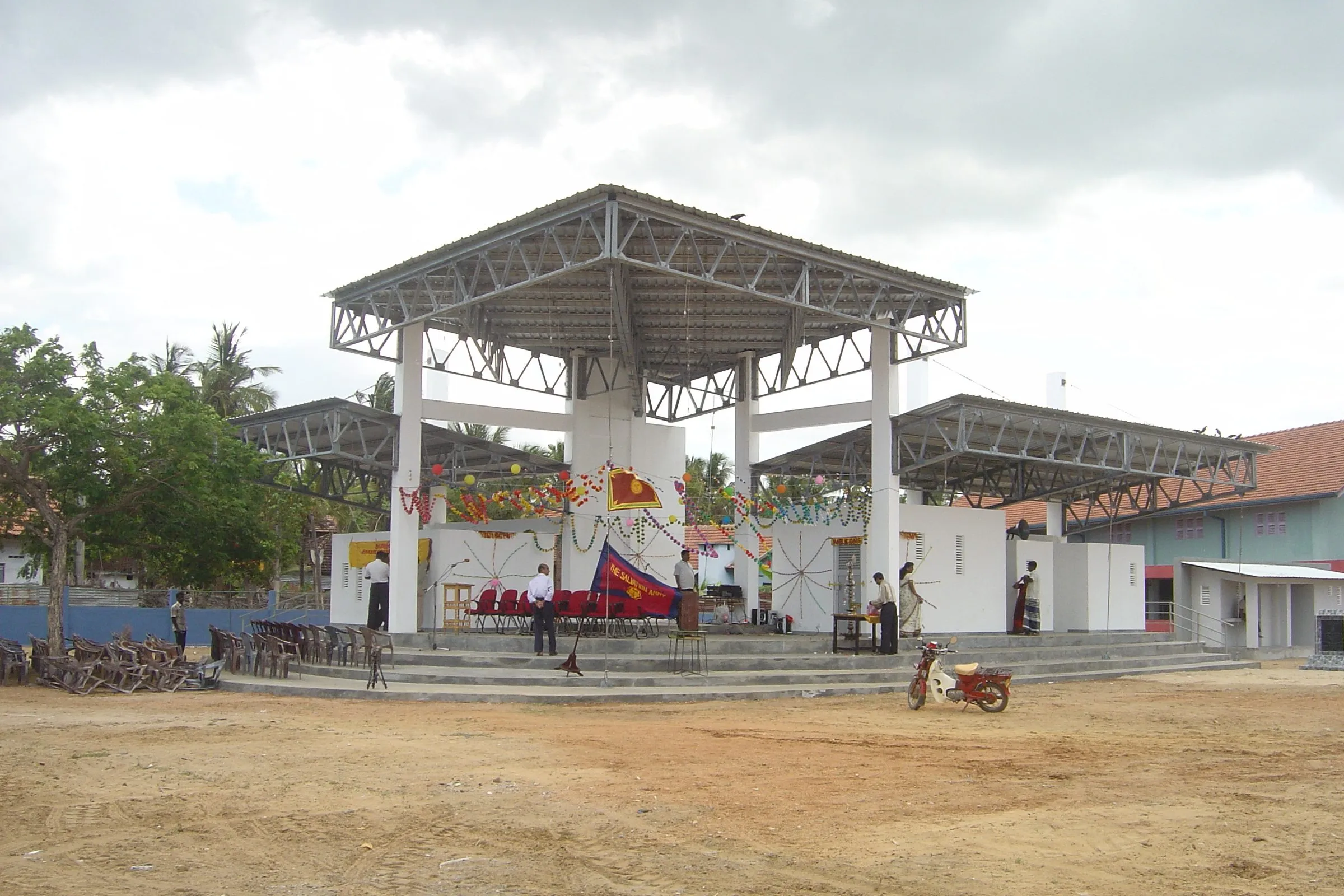 A pavilion on white piers, raised on tiered steps.
