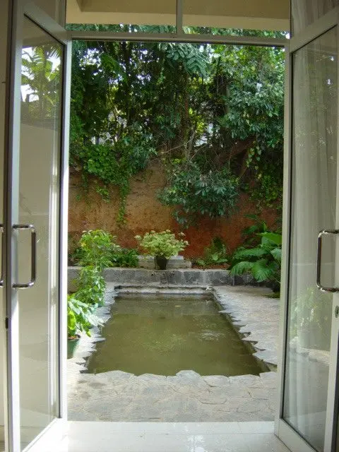 Glazed doors opening onto a narrow pond and garden.