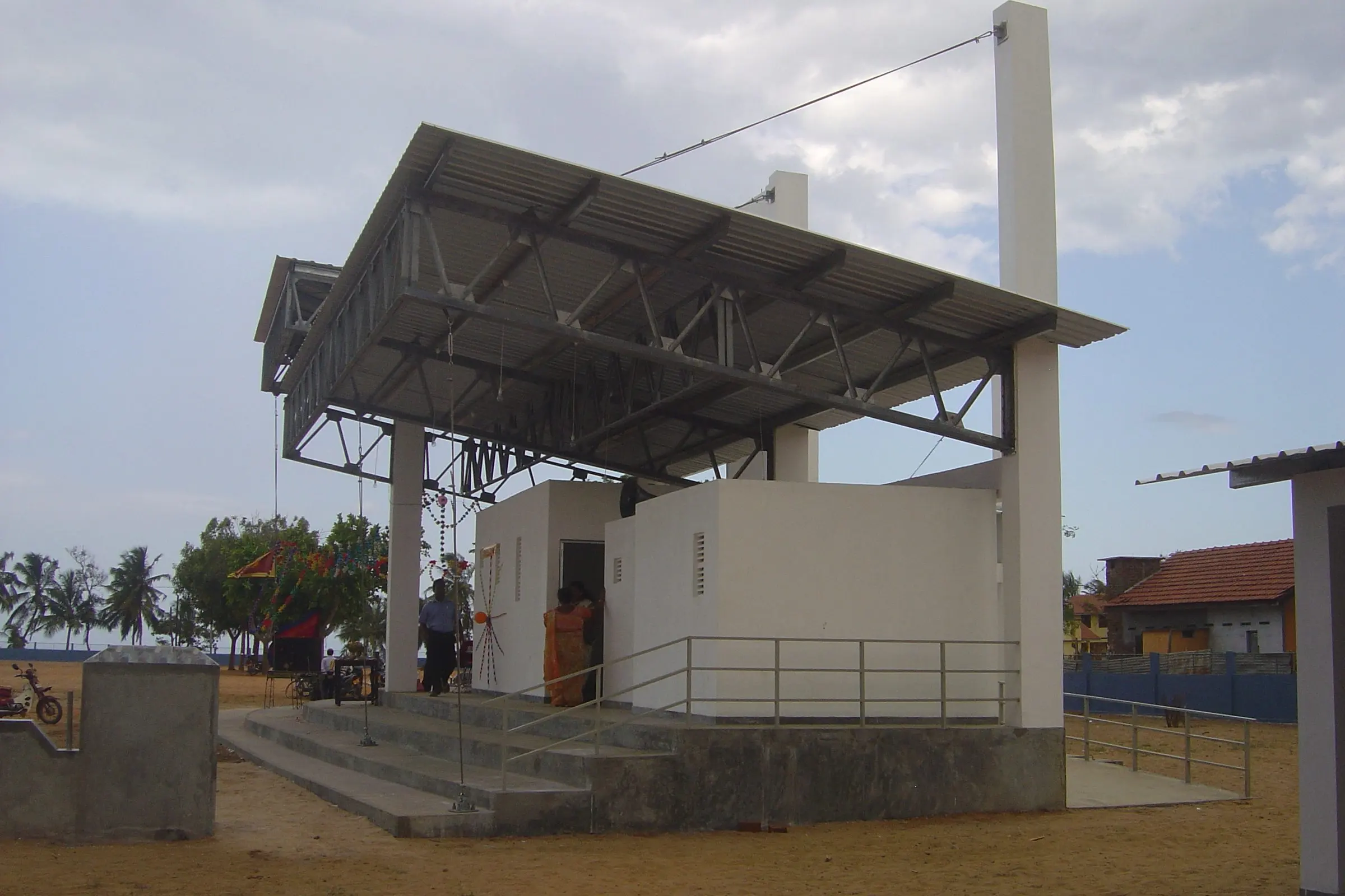 The pavilion from the side, beside a white single-storey block.