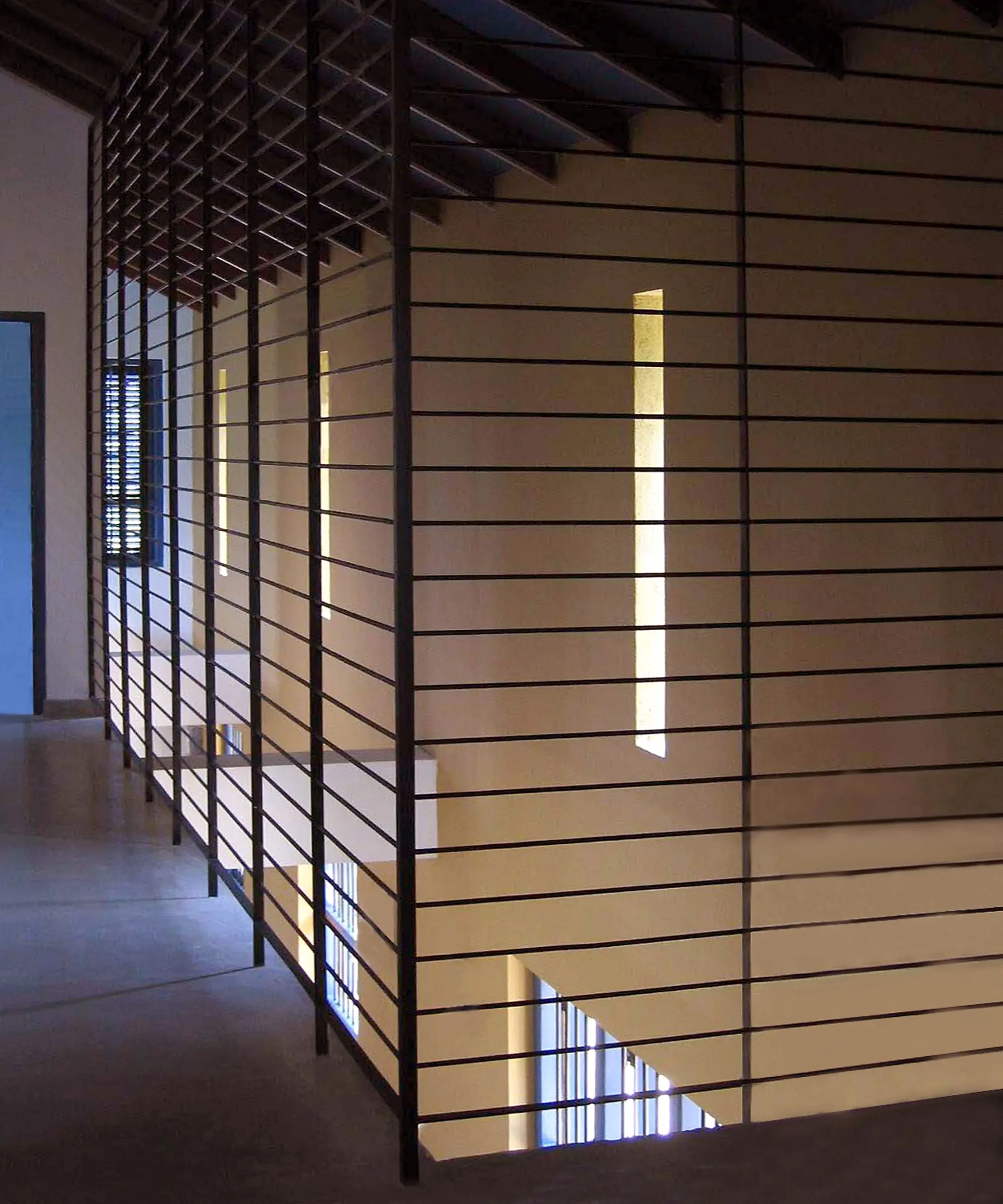 A horizontal-bar screen at the stair, with ochre walls beyond.