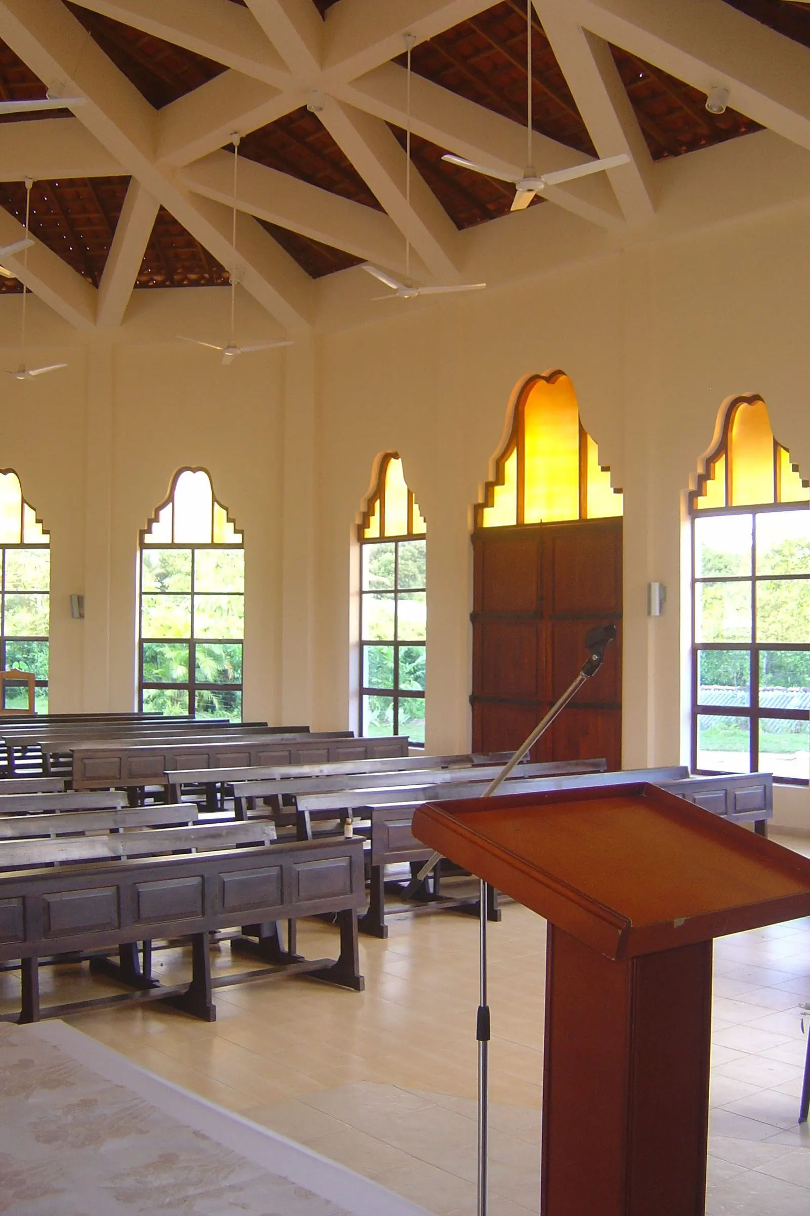 The nave, with arched windows, pews and a lectern.
