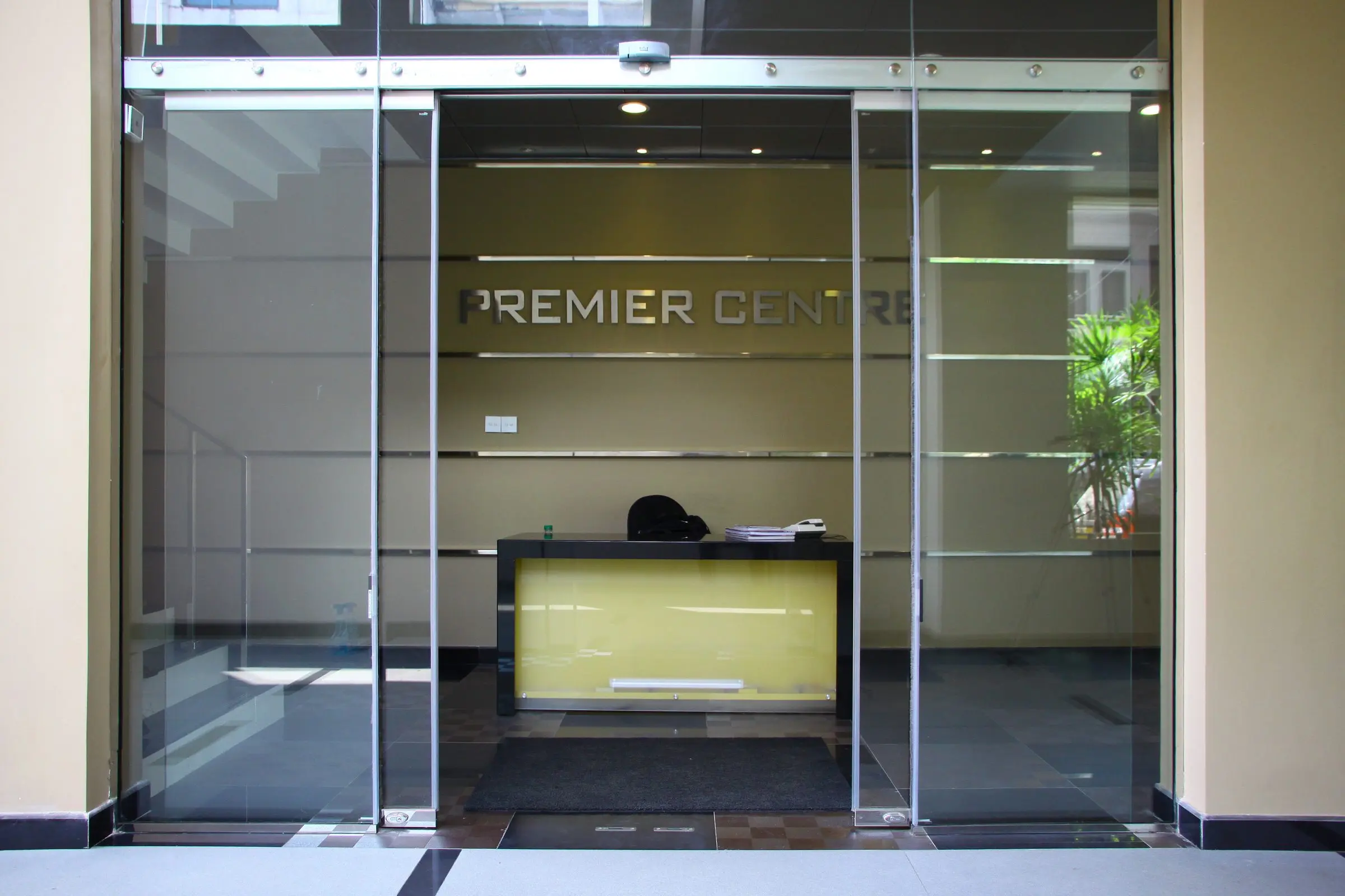 A glazed entrance lobby with a yellow reception desk — Commercial Building at Dr. N. M. Perera Mawatha, Colombo 08.