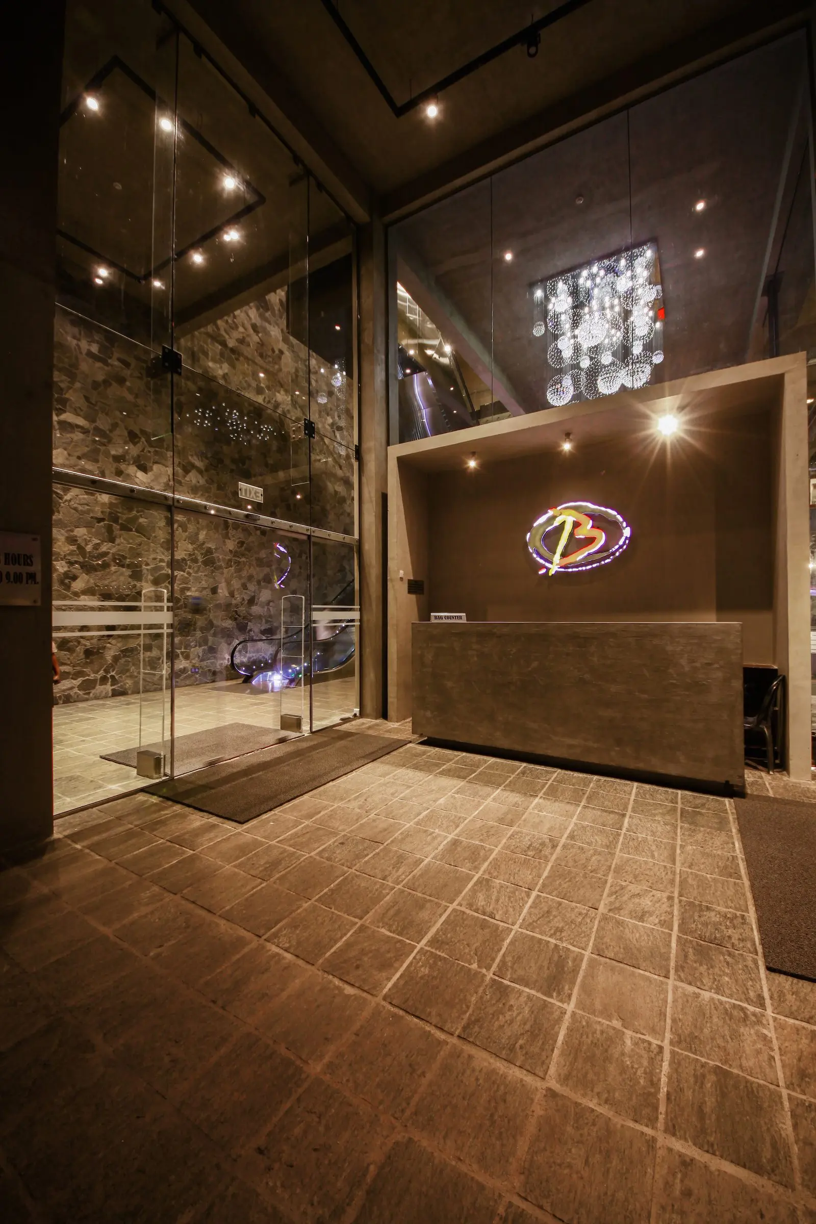 A glazed entrance lobby with a reception desk and a chandelier.